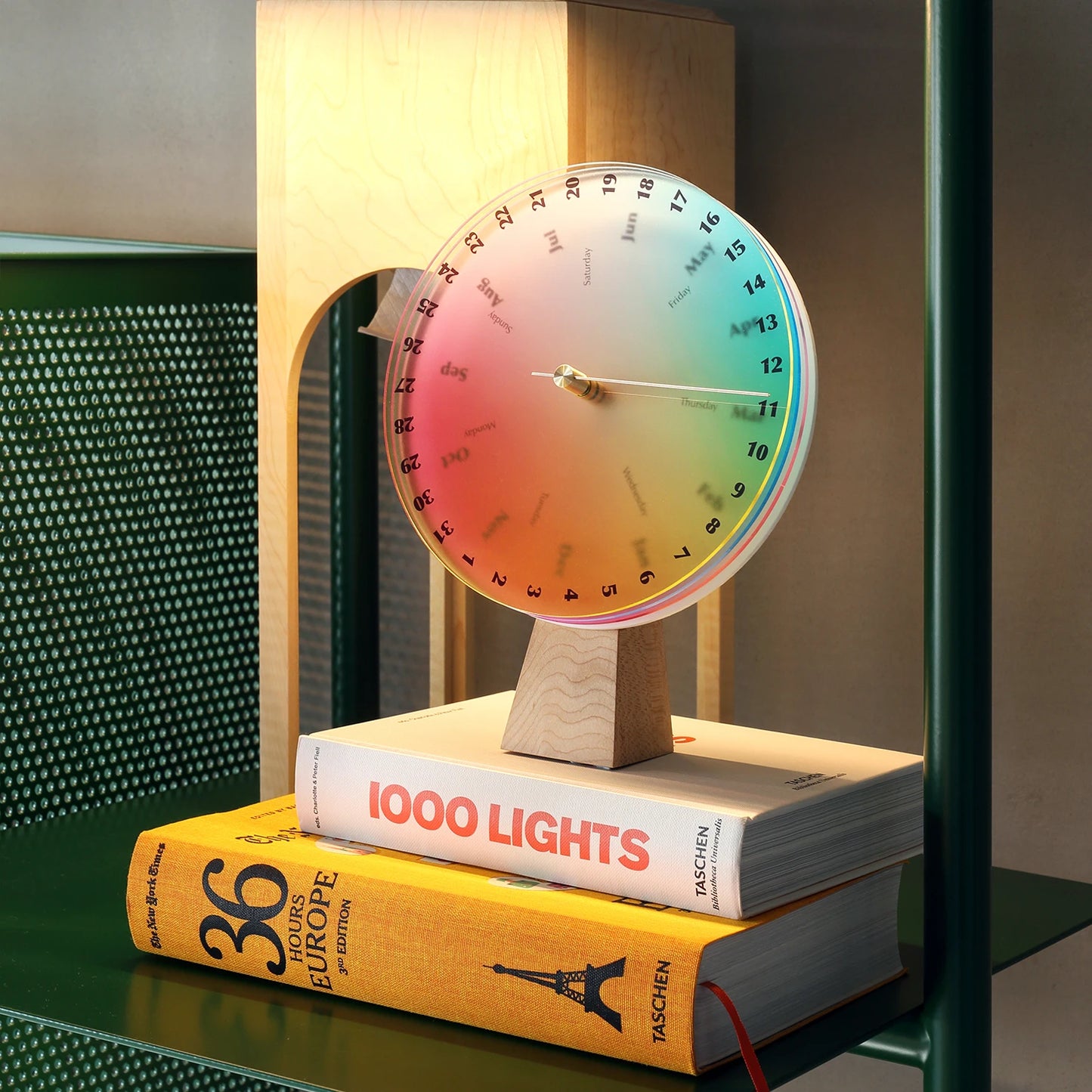 A modern color wheel calendar displayed on a stack of art books.