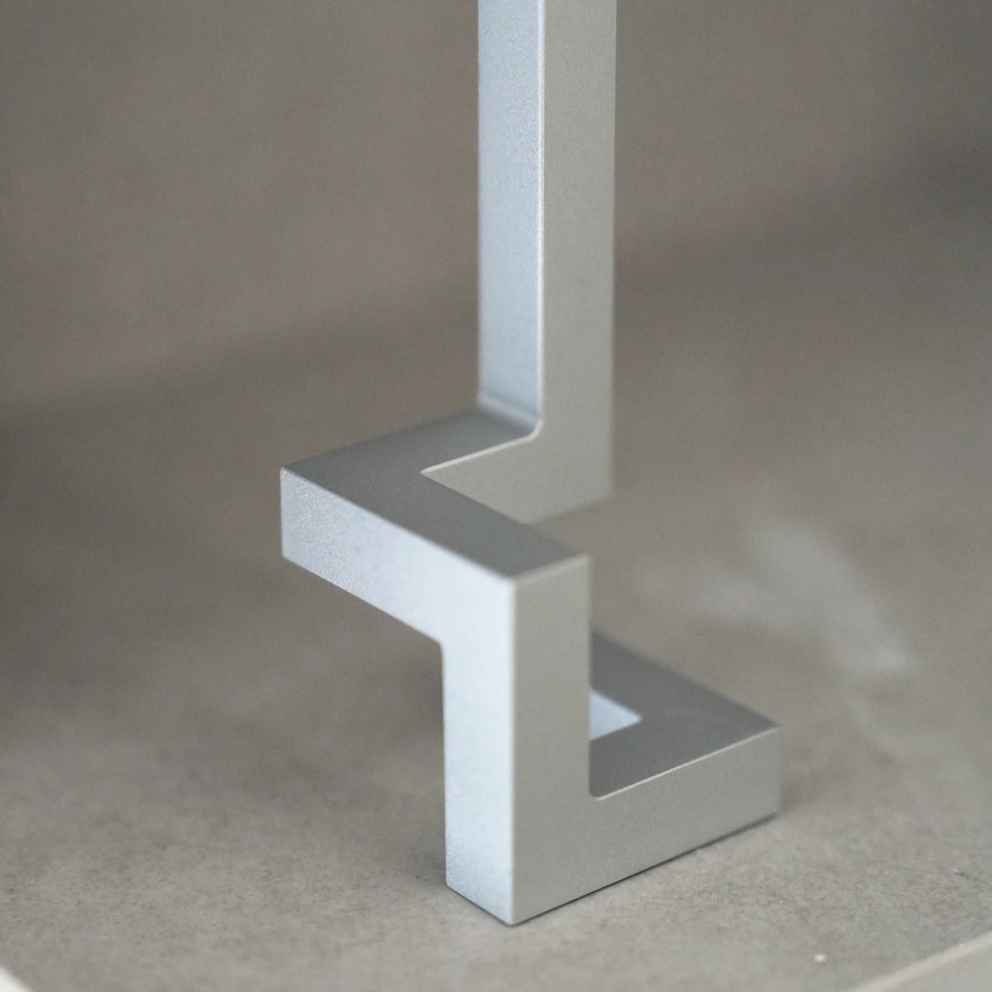 Close-up of a silver aluminum opener's geometric base on a shelf.