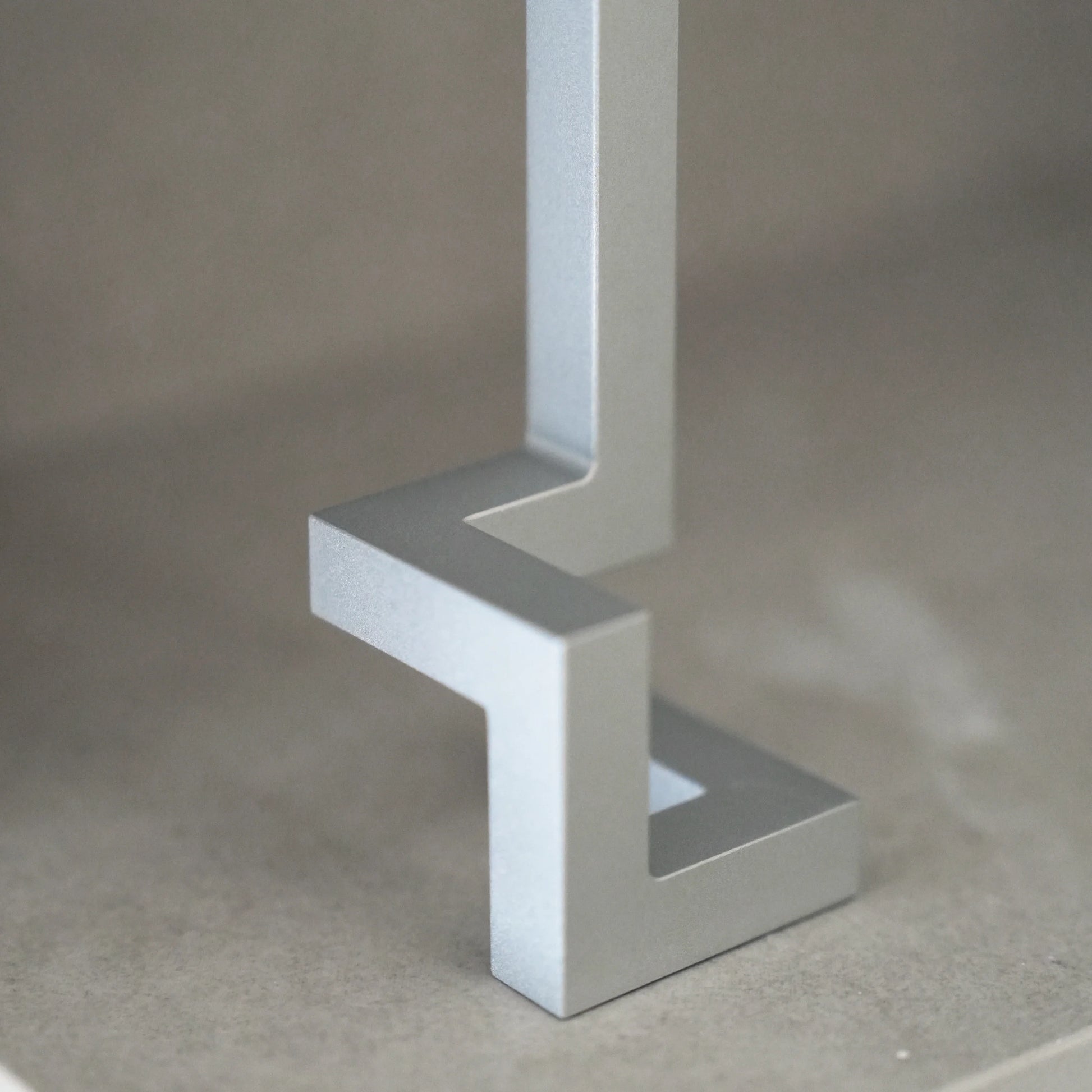 Close-up of a silver aluminum opener's geometric base on a shelf.