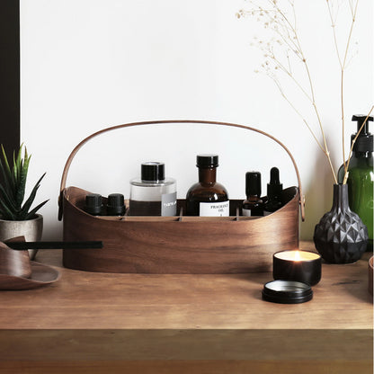A walnut bentwood caddy used as a skincare and fragrance organizer.