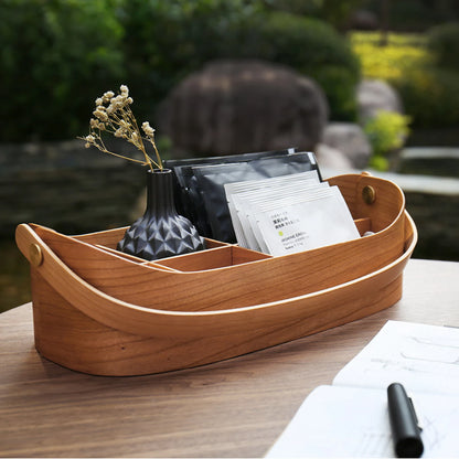 A cherry bentwood carry-all with tea bags styled on an outdoor table.
