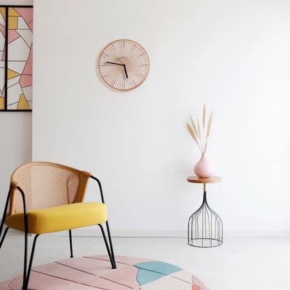 A bamboo wall clock styled in a modern room with a yellow chair.