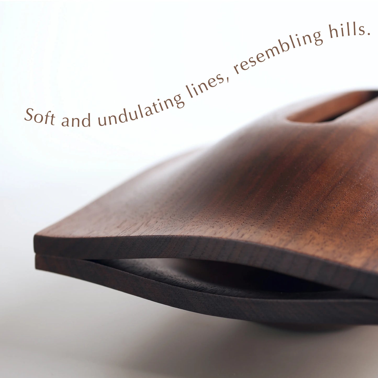Close-up of the undulating carved lines of a solid walnut tissue box.