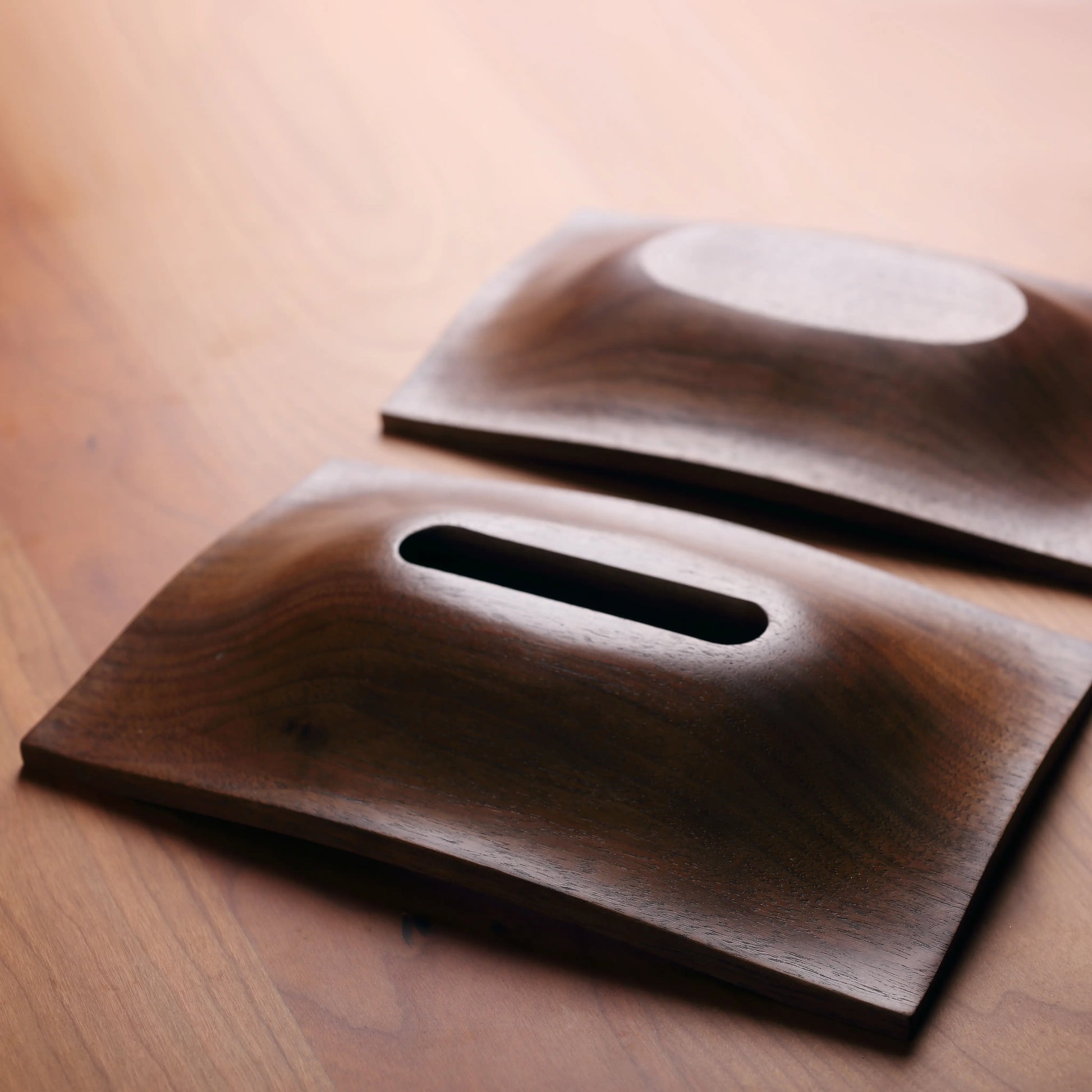 Lid and base of the walnut tissue box separated, showing refined underside carving.