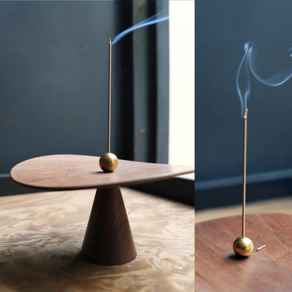 Split image of a sculptural walnut and brass incense holder burning.