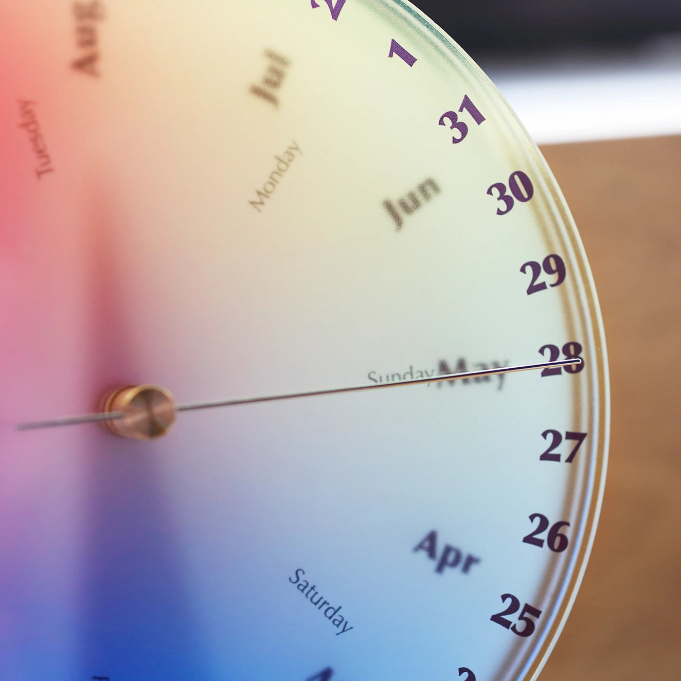 Close-up of the date hand on a colorful acrylic perpetual calendar.