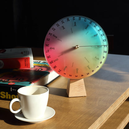 Colorful desk calendar with a coffee cup in dramatic morning light.