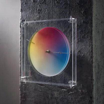 Modern color wheel clock mounted on a dark, textured concrete wall.