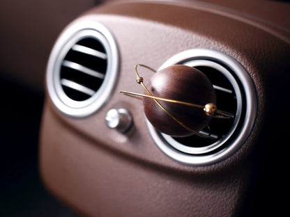 Angled view of the planet car vent diffuser in a leather interior.