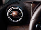 A planet-shaped car diffuser clipped to a circular car air vent.