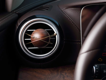 A planet-shaped car diffuser clipped to a circular car air vent.