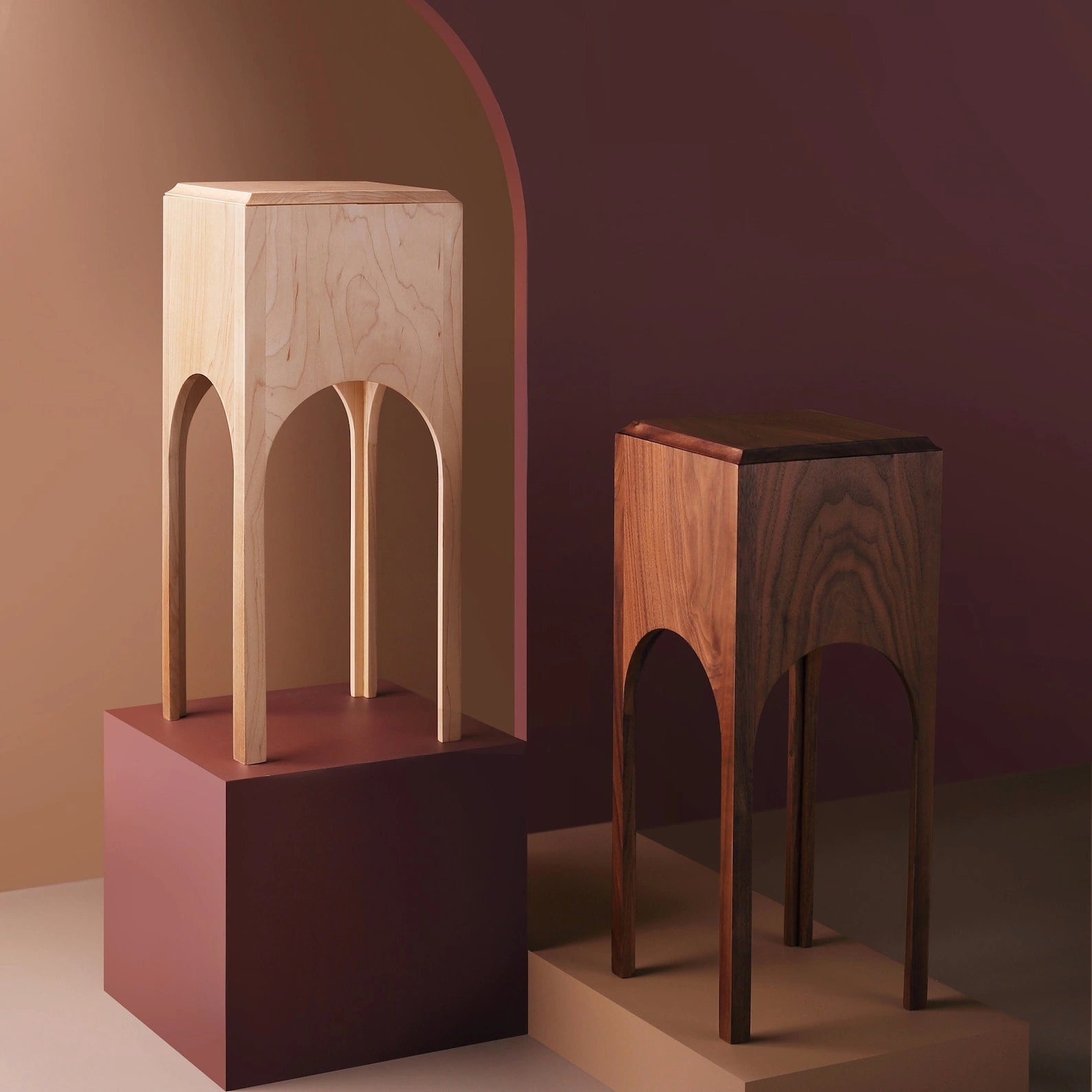 A maple wood tissue box tower standing next to a dark walnut version.