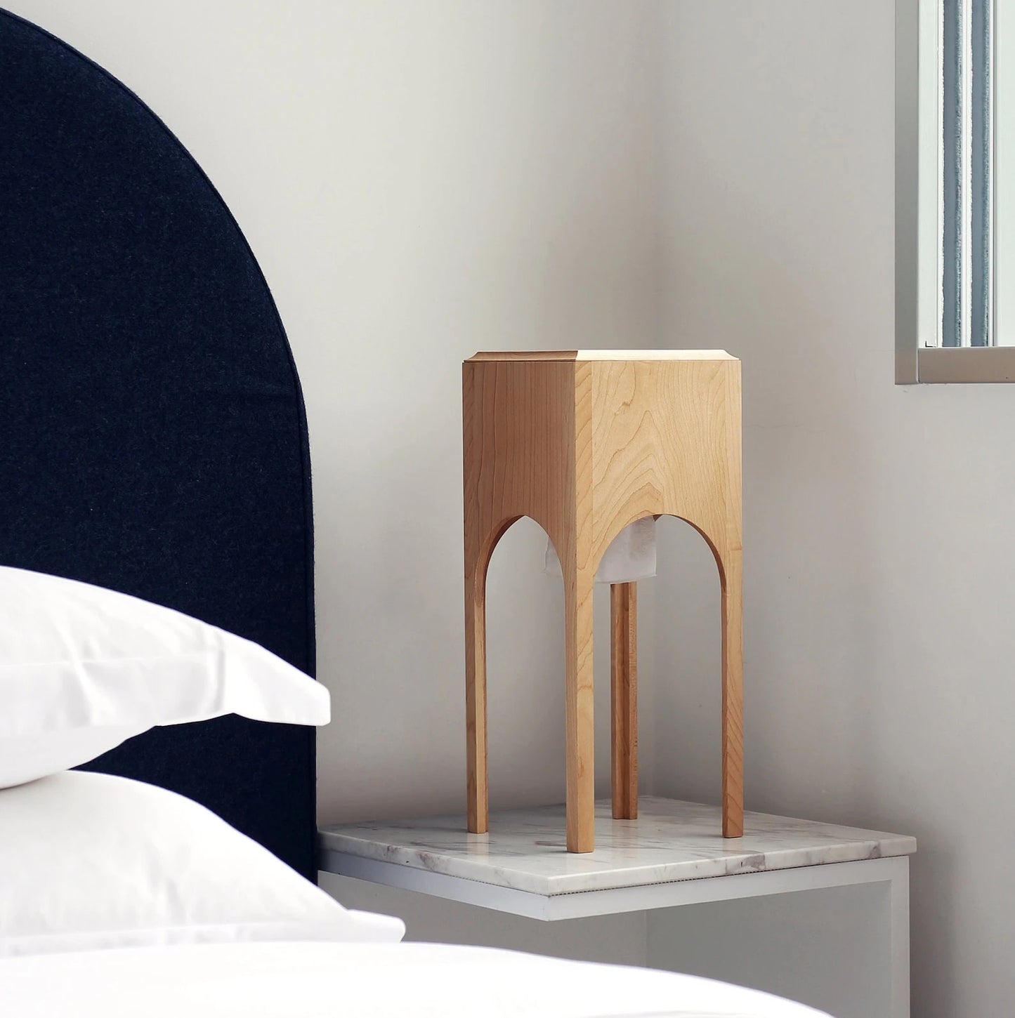 The tall maple tissue box styled as a bedside table accessory.