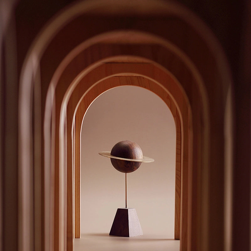 A sculptural planet diffuser seen through a series of wooden arches.