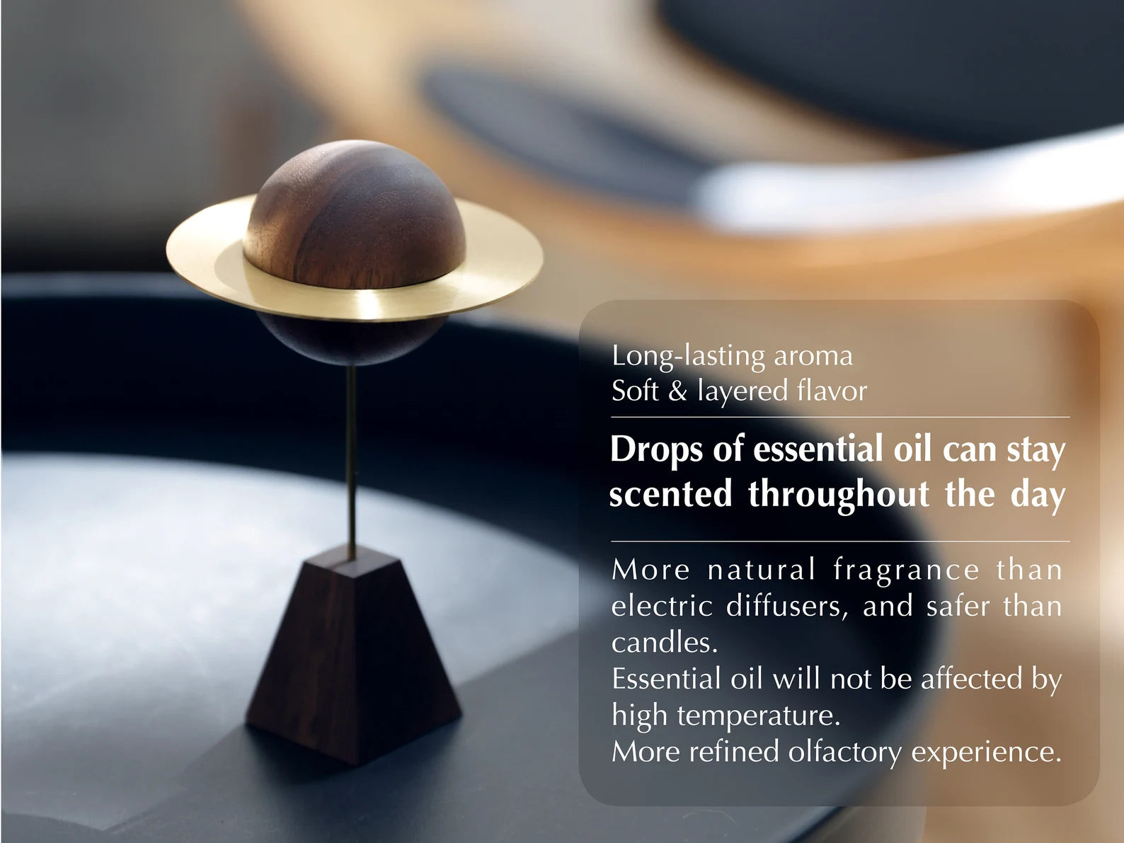 A modern planet diffuser on a black side table with a chair behind.