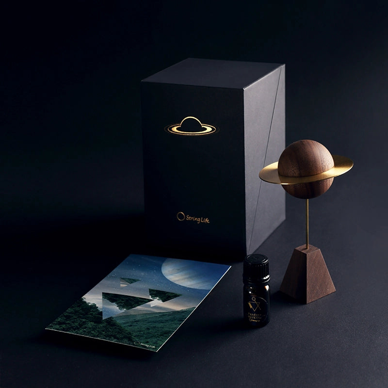 The complete gift set: planet diffuser, box, postcard, and oil bottle.