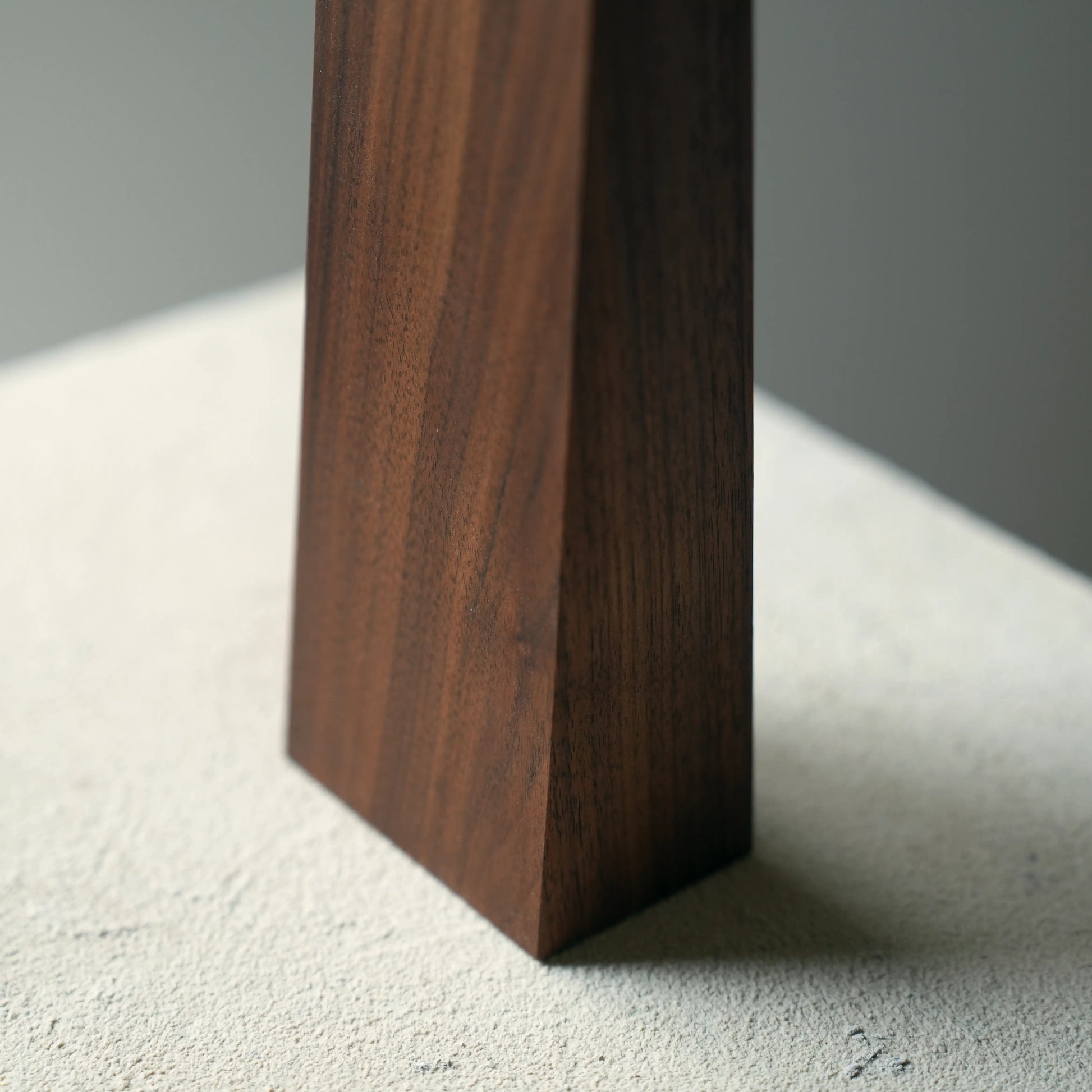 Detail of the dark, rich grain of the walnut geometric lamp base.