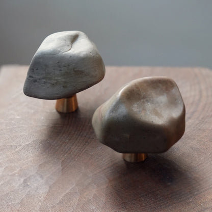 Two unique Gobi stone knobs with grey and brown tones on dark wood.