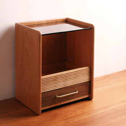 Angled view of wood and glass vanity organizer on a wood floor.