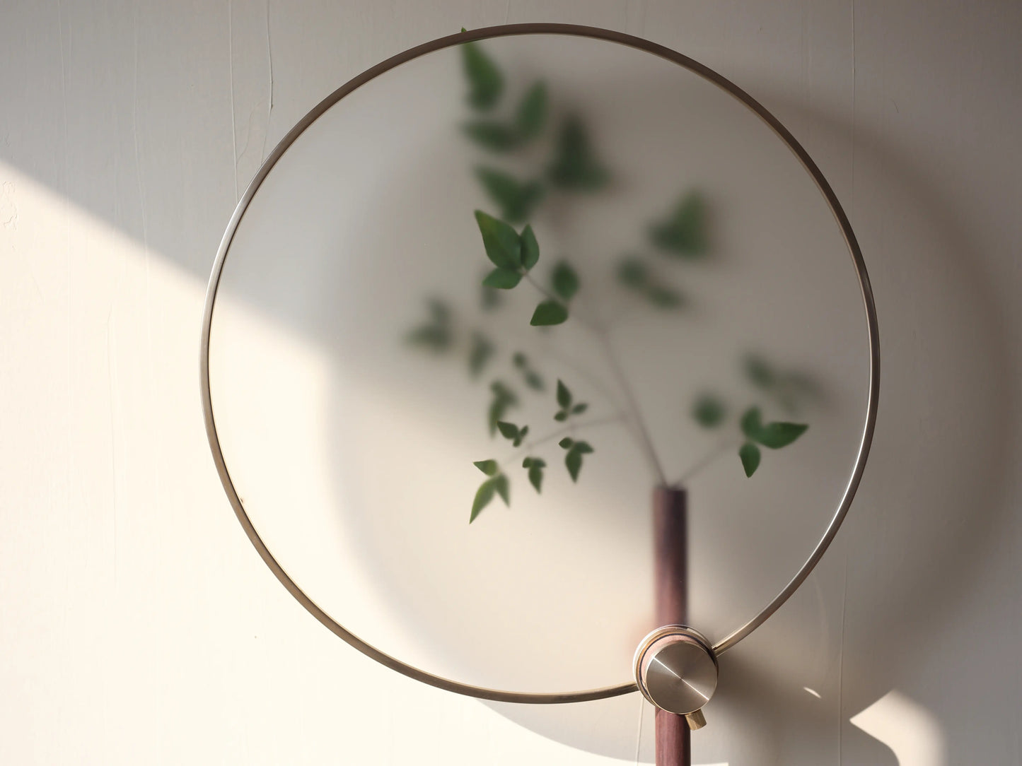Close-up of green leaves seen through the "fog effect" acrylic film of the wall vase.