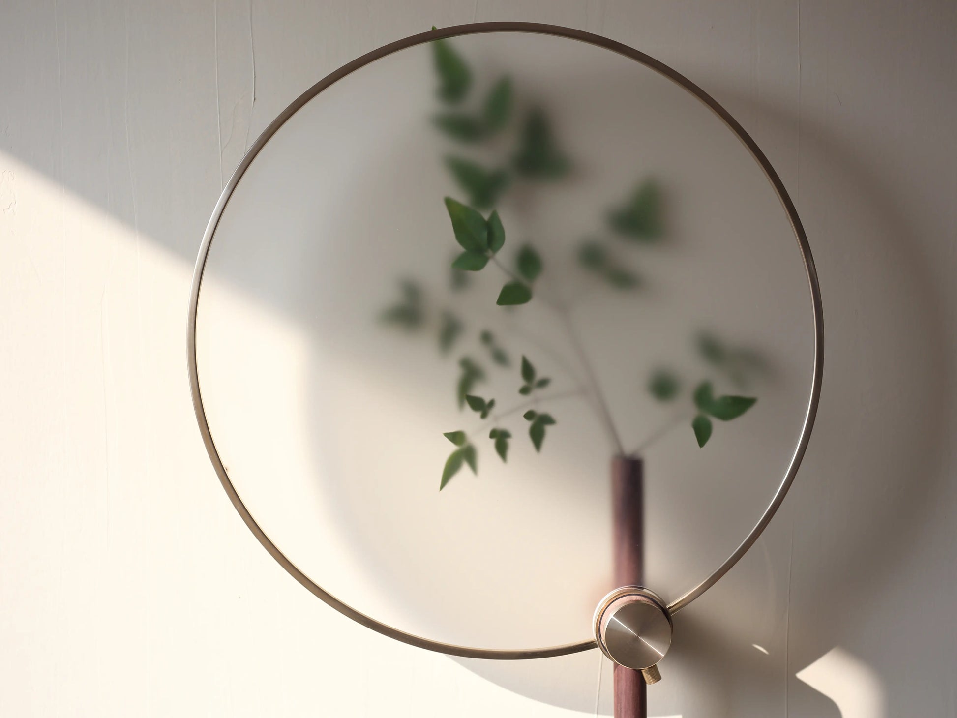 Close-up of green leaves seen through the "fog effect" acrylic film of the wall vase.