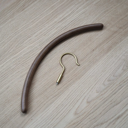 A disassembled view of the walnut hanger body and the brass screw-in hook.