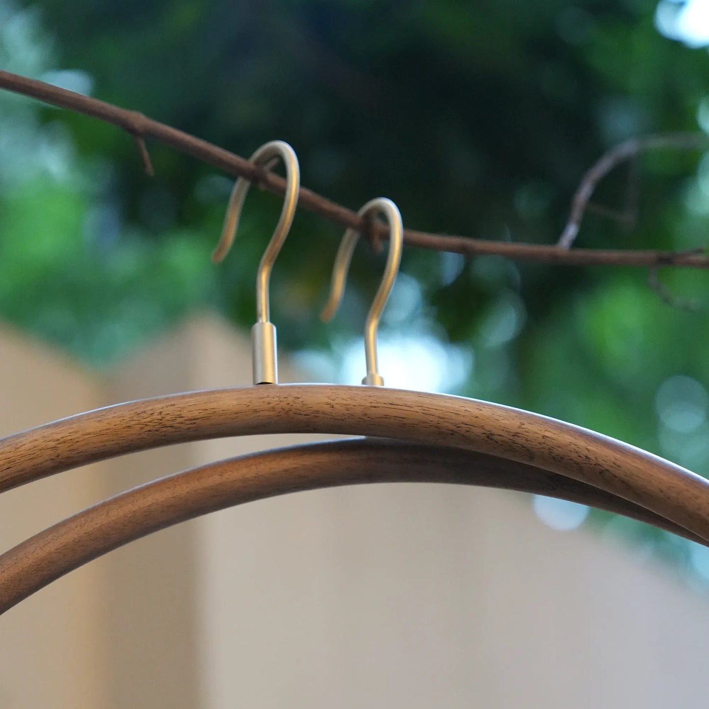 Angled view of the curved shoulder line on a solid walnut hanger.