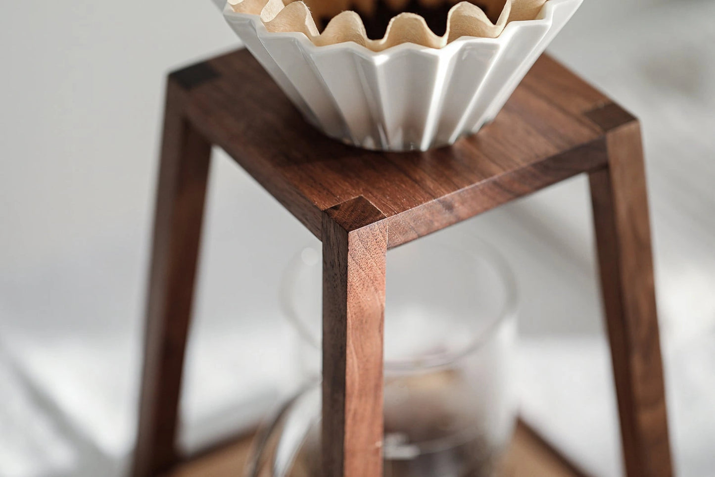 Close-up of the masterful wood joinery on a walnut pour-over coffee stand.