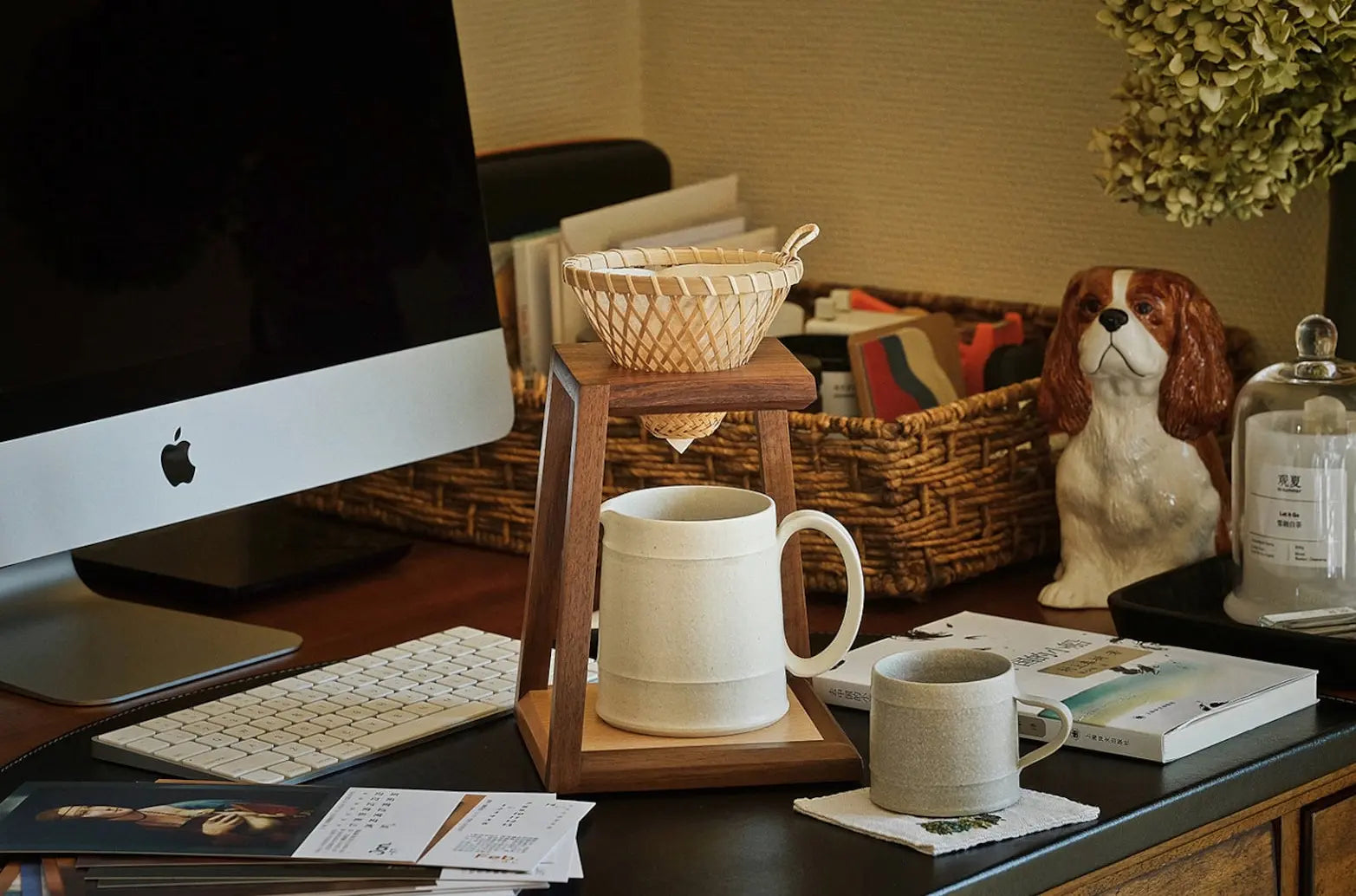 A walnut pour-over stand used with a bamboo dripper and a ceramic mug.