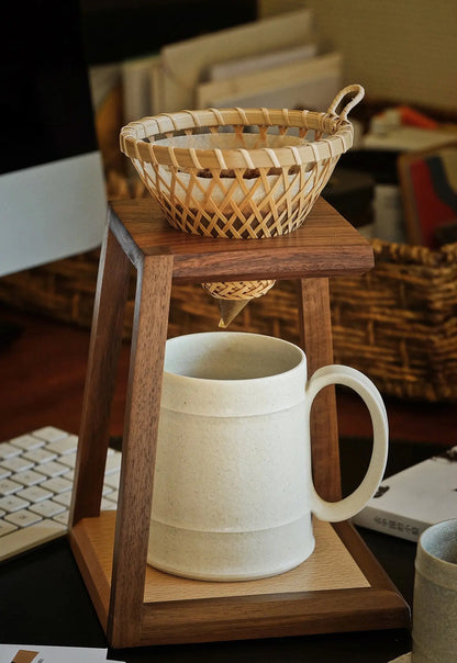 Close-up of a woven coffee dripper on the walnut pour-over stand.