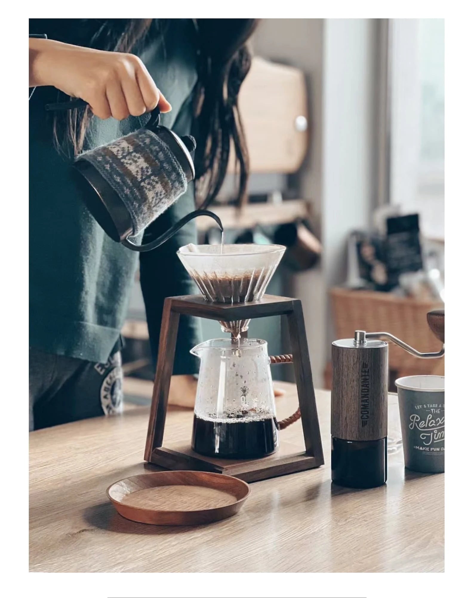 A complete coffee station with a walnut dripper stand and a coffee grinder.