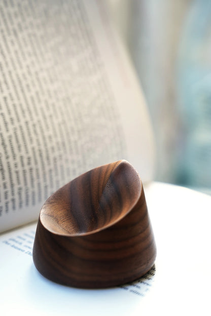 Top-down view of a carved walnut oil diffuser showing the smooth dish.