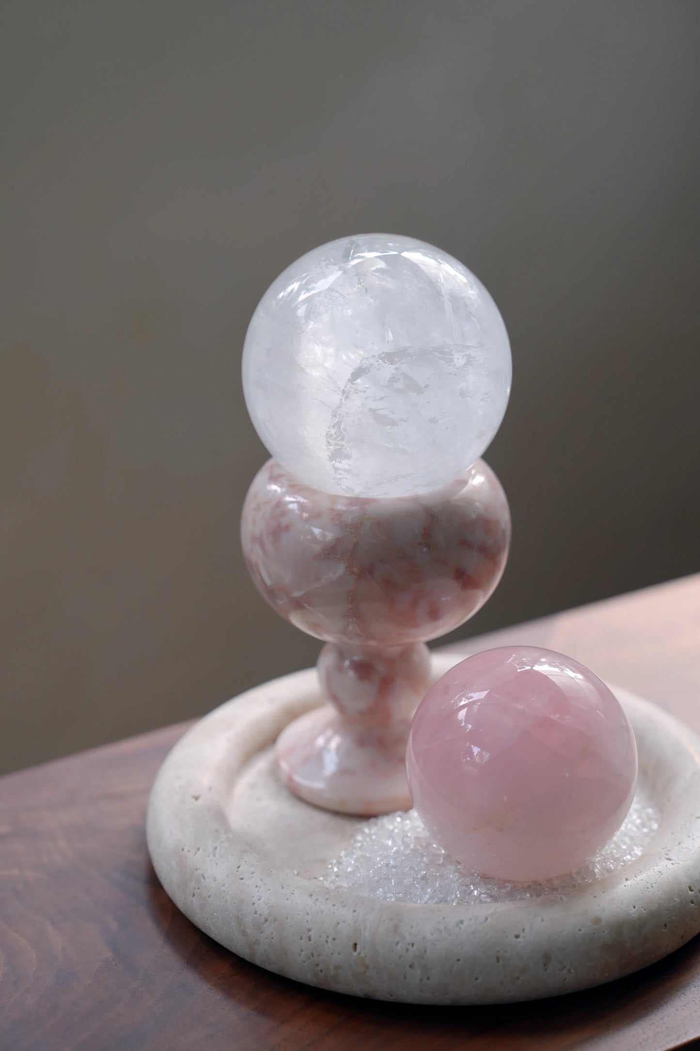 A pink marble sphere stand styled with a rose quartz sphere on a tray.