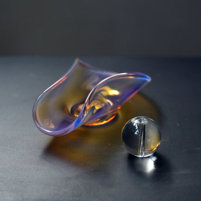 An iridescent glass incense dish and a separate glass sphere holder.