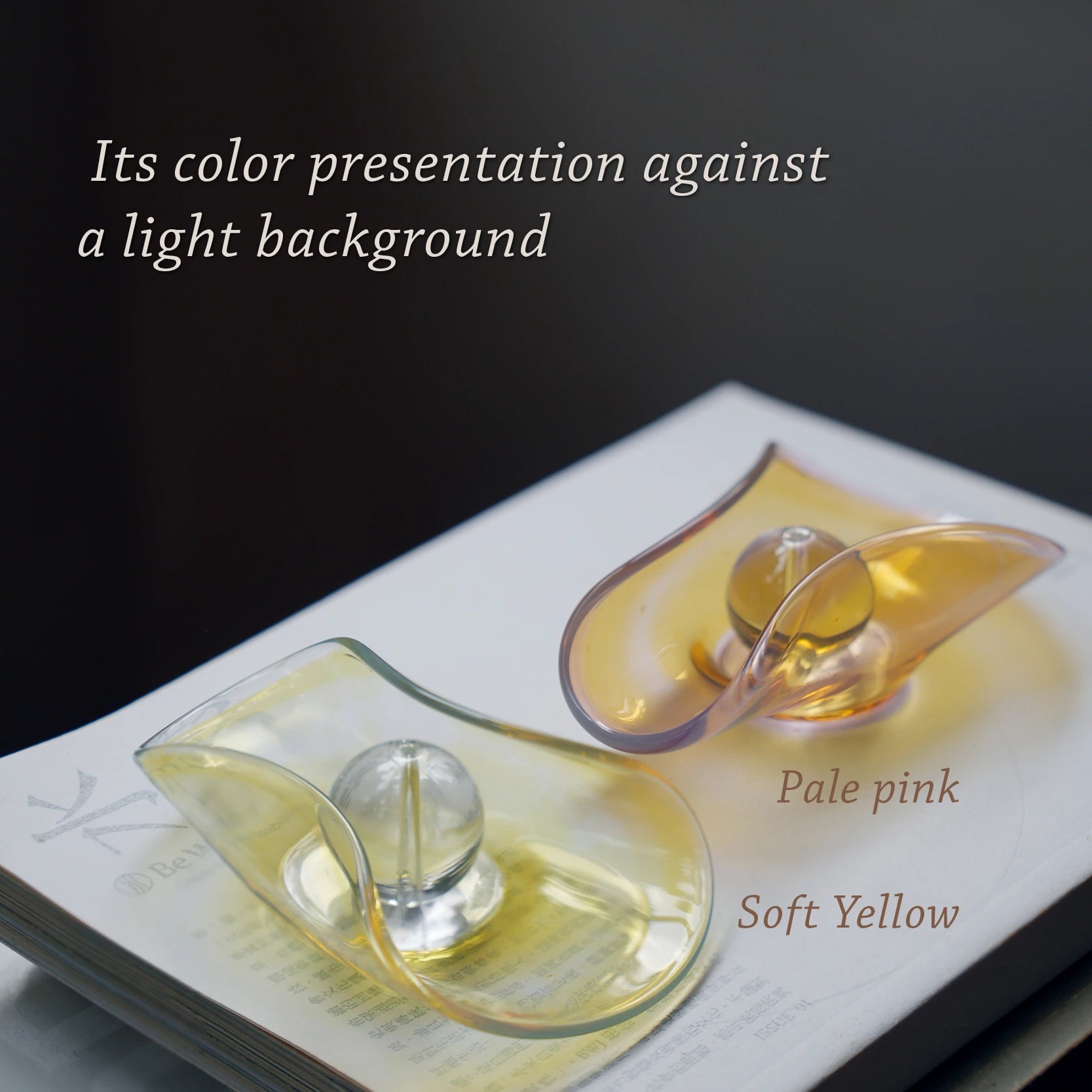 Two iridescent glass incense holders showing their colors on a light surface.