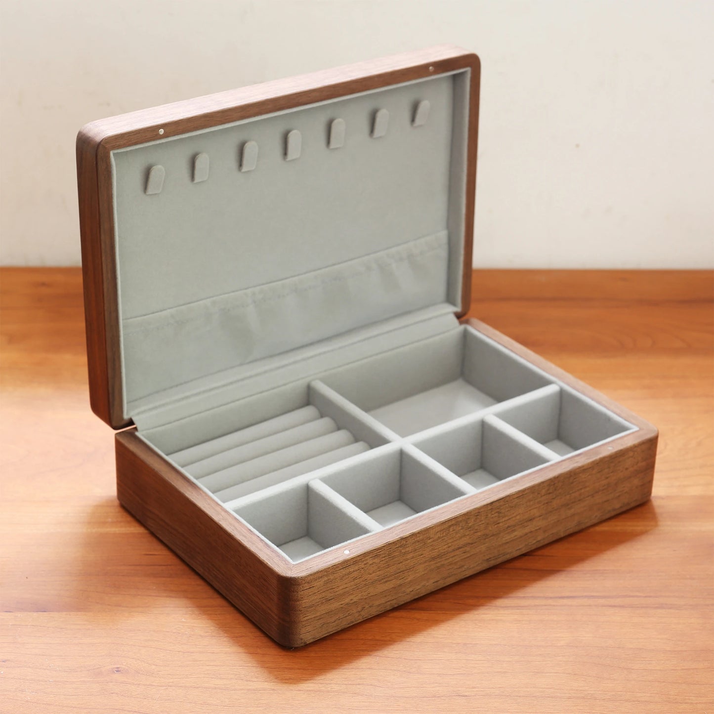 Open walnut wood jewelry box with a soft grey flannel interior.