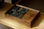 Walnut wood tray holding magazine on wood shelf, dark interior