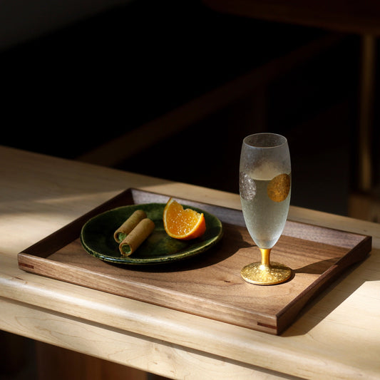 Walnut serving tray with glass and snack plate on wood table