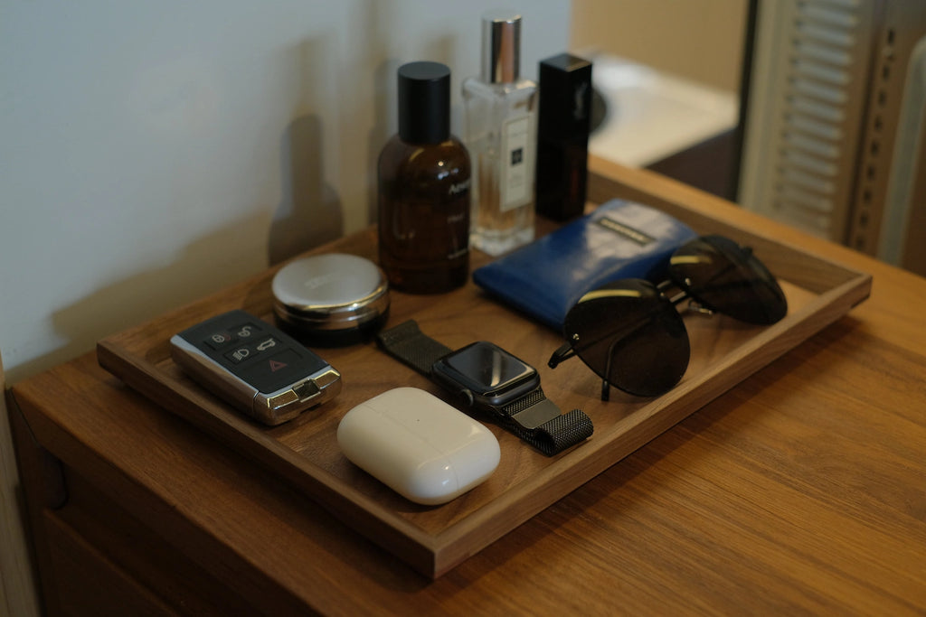 Walnut valet tray on dresser holding keys, watch, and sunglasses
