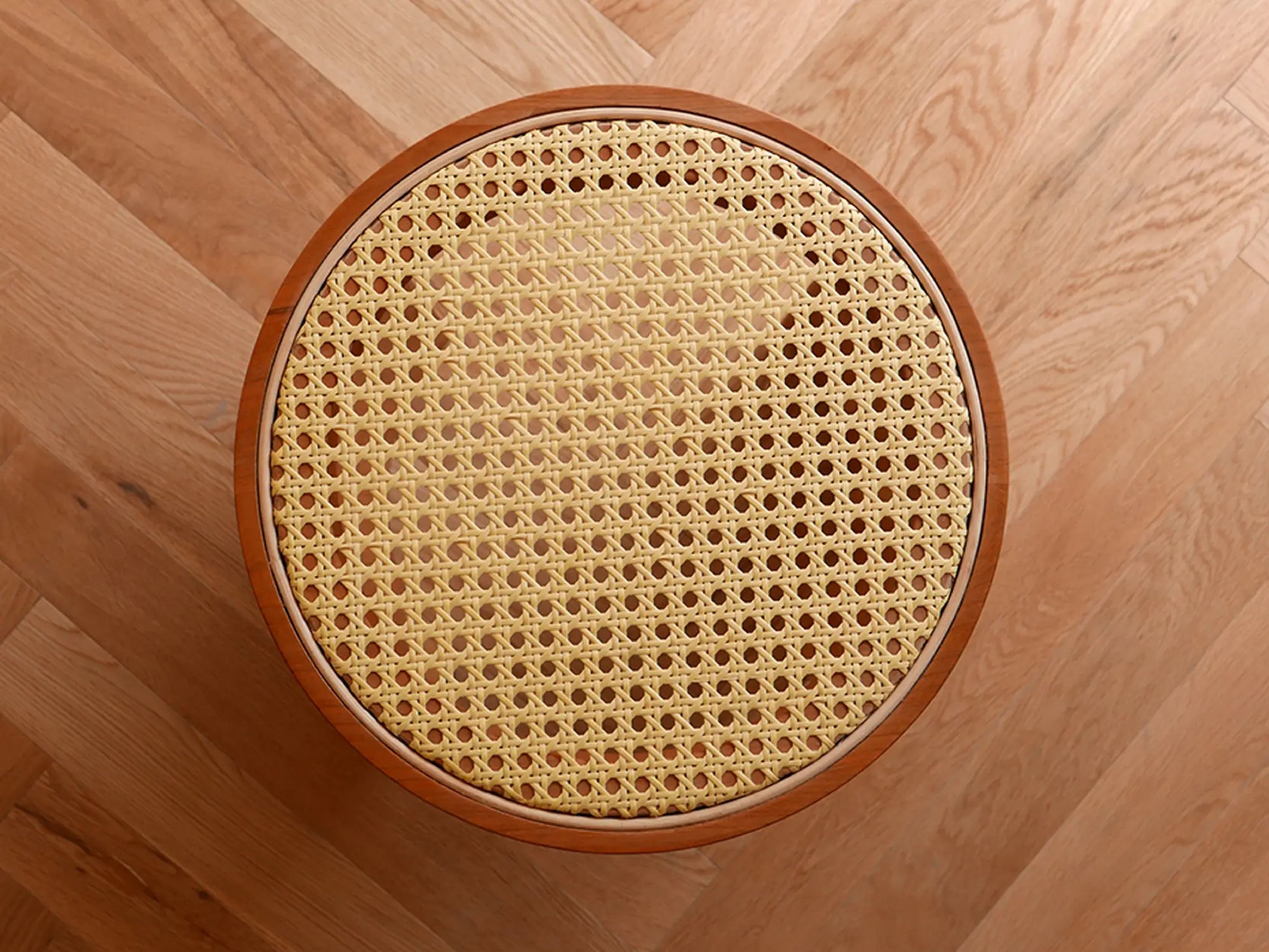 Top-down view of the hexagonal handwoven rattan pattern on the stool.